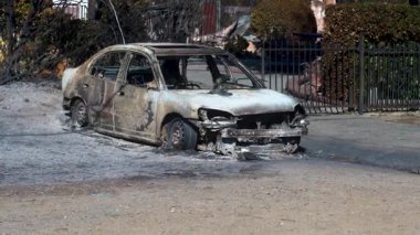 14 Ocak 2025 'te, Pasadena, Kaliforniya, ABD' de yıkıcı bir yangından sonra yanmış bir arabanın yakın çekimi. Görüntülerde kül ve molozlarla çevrili kömürleşmiş aracın arka planı vurgulanıyor.