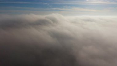 4k 'lık bir hava görüntüsü, güneş ışığının içinden geçerek sakin ve huzurlu bir atmosfer oluşturduğu sakin bulutları gösteriyor. Yüksek kalite 4k görüntü