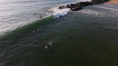 Los Angeles, Kaliforniya 'da Venedik Sahili dalgaları etrafında sörf yapan sörfçülerin şaşırtıcı yavaş çekim görüntüleri. İnsansız hava aracı sörfçüleri takip eder ve mükemmel dalgayı bekler.