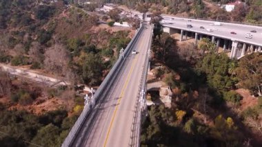 Colorado Köprüsü 'nün havadan çekilmiş görüntüleri. Pasadena, California, ABD' de. Beyaz bir araba geçiyor. 20. yüzyılın başlarında inşa edilen bu tarihi köprü zarif kemerlere ve