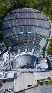 Hava aracı geri çekilmesi Hollywood Bowl amfi tiyatrosunun Los Angeles 'ın Hollywood Tepeleri' nde kurulduğunu gösteriyor. Yeşilliklerle çevrili bu ikonik açık hava mekanı, genişleyen şehirle çelişiyor.