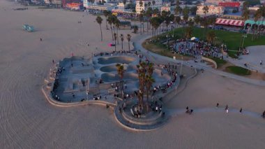 Havadan. Paten sahası düz hatlara sahiptir ve güzel bir şekilde uzun palmiye ağaçları ve kumlu bir plajla çevrilidir. Venedik plajı, LOS ANGELES, CALIFORNIA, ABD, 10 Ekim 2024. Yüksek kalite 4k