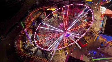 Santa Monica, LOS ANGELES, CALIFORNIA, ABD, Ekim 10, 2024. Pasifik Parkı 'ndaki yanan dönme dolabın hava görüntüleri. Karnaval yolculuğunun canlı ve renkli ışıkları geceleyin yakalanır. Yüksek