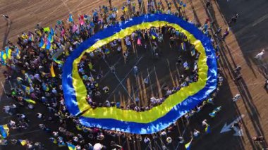 Santa Monica, California, 23 Eylül 2025 'te Santa Monica İskelesi' nde büyük bir Ukrayna bayrağını açan büyük bir insan topluluğu görüntülendi. Katılımcılar Ukraynaca el sallıyor ve