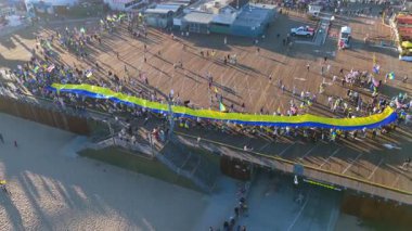 23 Şubat 2025 'te Santa Monica İskelesi, Kaliforniya' da Ukrayna bayrağı yürüyüşünü çekerken nefes kesici bir panoramik çekim yapıldı. Yüzlerce katılımcı gururla uzatılmış mavi ve sarı bir bayrak taşıyor.