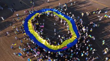 23 Şubat 2025 'te Santa Monica İskelesi Kaliforniya' da Ukrayna bayrağıyla çember oluşturan büyük bir insan grubunu çeken güçlü bir hava görüntüsü. Katılımcılar gururla Ukrayna bayraklarını sallıyor ve