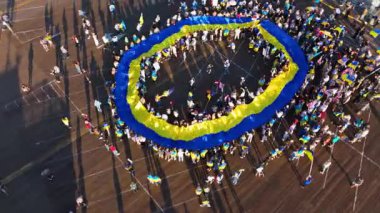 Editör görüntüleri. 23 Şubat 2025. Hava aracı görüntüleri, Santa Monica İskelesi, Los Angeles, Kaliforniya 'da büyük bir Ukrayna bayrağının çarpıcı dairesel oluşumunu kaydeder. Katılımcılar çevreyi sardı