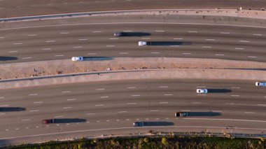 Bu video, trafiğin dinamik akışını ve modern ulaşımı gösteren, seyrüsefer yapan arabaların bulunduğu yoğun bir otoyolun havadan görüntüsünü sunuyor. Universal City, Los Angeles, ABD, 2024. Yüksek kalite 4k