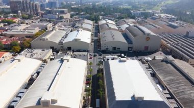 İnsansız hava aracı 29 Mart 2025 'te Los Angeles, Kaliforniya' daki Warner Bros. stüdyoları üzerinde uçuyor. İkonik ses aşamalarını, üretim binalarını ve stüdyo altyapısını kaydetmek. Sahnelerin paralel satırları derinlik oluşturur