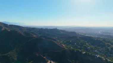 Hollywood Hills 'in nefes kesici panoramik manzarası. 6 Mart 2025' te Los Angeles silueti arka planda. Şehir manzarası ufukta yuvarlanan tepeler ve lüks evler tarafından çerçevelenmiş. A