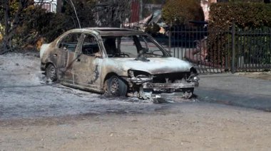 14 Ocak 2025 'te, Pasadena, Kaliforniya, ABD' de yıkıcı bir yangından sonra yanmış bir arabanın yakın çekimi. Görüntülerde kül ve molozlarla çevrili kömürleşmiş aracın arka planı vurgulanıyor.