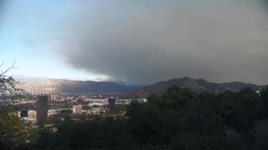 Dramatik bir hava görüntüsü, yakındaki bir yangından kaygı verici bir şekilde yükselen dumanla geniş bir şehir manzarası sunuyor. Pasadena, California 'da çıkan yangından sonra. 8 Ocak 2025 'te yakalandı. Yüksek
