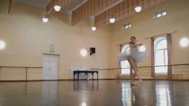 Sivri pabuçlu güzel balerin ve beyaz bale eteği ile piruet yapılır. Dans stüdyosundaki genç klasik dansçı kadın. Bale sınıfı eğitimi. Bale okulu konsepti. Tek bir yerde dönüyor. A