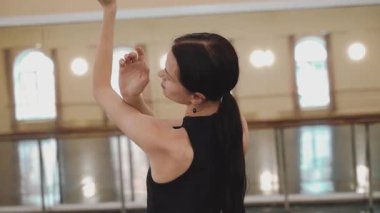 Dairesel. Kapatın. Profesyonel bir balerin salonun ortasında güzel hareket eder. Plastik el hareketleri, plastik el hareketleri. Dans stüdyosundaki genç klasik dansçı kadın. Bale sınıfı