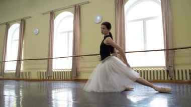 Sivri uçlu ayakkabılı balerin ve tiyatronun prova salonunda dans edip prova yapan beyaz etekli balerin. Zarif bir klasik bale dansçısı koreografi yapar. Kyiv, Ukrayna 2019. Yüksek kalite 4k