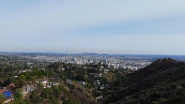 Çarpıcı hava görüntüleri, Los Angeles, California üzerinden Hollywood Hills 'in avantajlı noktasından geriye doğru bir uçuş kaydediyor. İnsansız hava aracı, gökdelenlerin ve kentlerin bulunduğu nefes kesici bir şehir manzarası ortaya çıkarıyor.