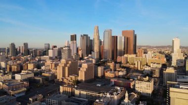 Los Angeles, California şehir merkezinin havadan görünüşü, gün doğumunda altın sabah ışığı banyosu. 2 Ocak 2025 'te yakalanan bu görüntüler canlı şehir siluetini ve ikonik gökdelenleri vurguluyor.
