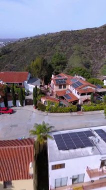 Los Angeles California 'daki lüks yamaçlı villaların dikey drone görüntüleri. Güneş panelleri ve havuzları olan bu elit evler çarpıcı manzaralar ve sürdürülebilir yaşam sunuyor. Sosyal medya makaraları için mükemmel