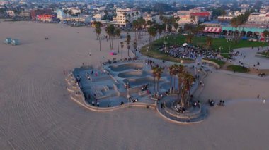 Büyüleyici bir manzara, çarpıcı bir günbatımına karşı hazırlanmış kıvrımlı ve rampalı modern bir kaykay parkını gösteriyor. Venedik plajı, LOS ANGELES, CALIFORNIA, ABD, 10 Ekim 2024. Yüksek kalite 4k görüntü