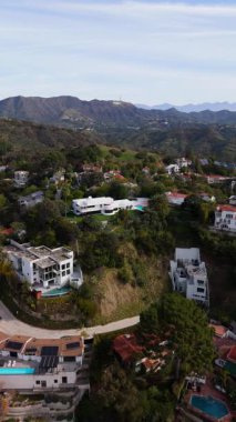 İHA görüntüleri Los Angeles, Kaliforniya 'daki Hollywood Tepelerinin manzaralı güzelliğini yakalıyor. Tepesinde ikonik Hollywood işareti var. Yeşillik ve konutlar geniş bir alana yayılıyor.