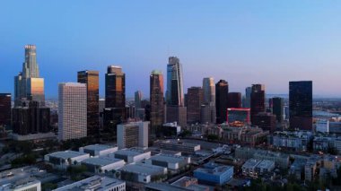 11 Nisan 2025 'te gün batımında Los Angeles şehir merkezinin sabit hava görüntüsü. Gökdelenler, modern kuleleri ve konut binalarını aydınlatan altın gece ışığını yansıtıyor. Panoramik