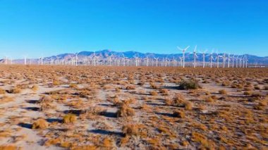 Uzak dağların çerçevelediği uçsuz bucaksız bir rüzgâr çiftliğine doğru kurak zeminden uçuyor. Sahne, doğal arazi ve temiz enerji teknolojisinin birleşimini yakalıyor. Sürdürülebilirlik temaları için mükemmel