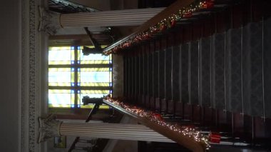 Noel ve Yeni Yıl iç dekorasyonu. Evdeki antik merdivenler oyuncaklar, hediyeler, hediye kutuları, parlayan çelenkler, yanan lambalar ile süslenmiş. Sıcak Noel atmosferi. Güzel