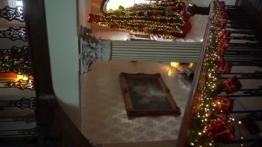Çok güzel dekore edilmiş bir merdiven. Festival ışıkları, süsler ve bayram mevsimi aşkı ile dolu. Yılbaşı ağacı, eski bir kır evinin lüks içinde. Ağır çekim. Yüksek