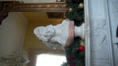 Çarpıcı bir mermer büst, klasik estetik güzelliği artırmak için festival dekorasyonları arasında güzelce sergileniyor.