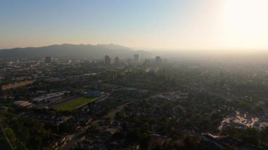 Glendale 'in Los Angeles, Kaliforniya' daki hava görüntüsü, 14 Nisan 2025 'te, altın saat sırasında çekildi. İnsansız hava aracı yerleşim bölgeleri, dolambaçlı sokaklar ve geniş bir şehir manzarası üzerinde ilerliyor.