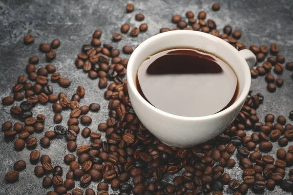 Zbliżenie Widok Brązowych Nasion Kawy Filiżanką Kawy Ciemna Powierzchnia Teksturowane — Zdjęcie stockowe
