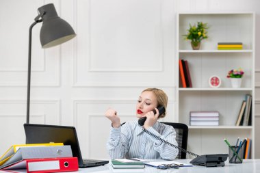 Ofiste çalışan sekreter. Gömleği iş yükü olan sevimli sarışın kız.