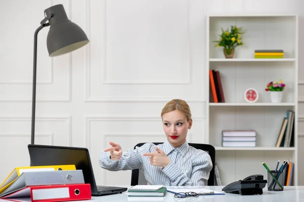 secretary lovely cute blonde young girl in shirt in office with work load pointing far