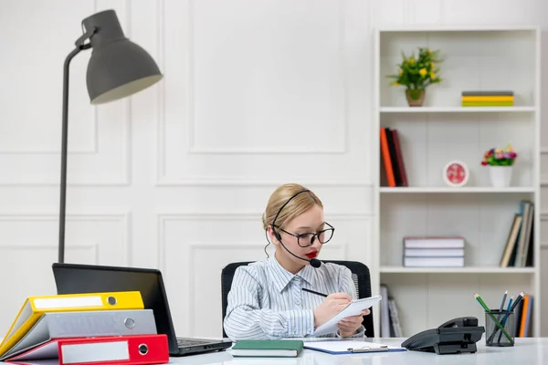 secretary working in office cute lovely young blonde girl in shirt with work load writing notes