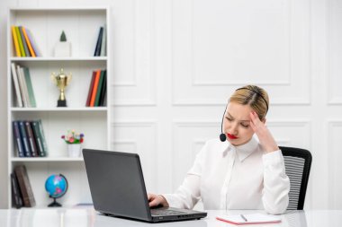 Müşteri hizmetleri şirin sarışın ofis tişörtü, kulaklık ve bilgisayar başlığı yorgun.