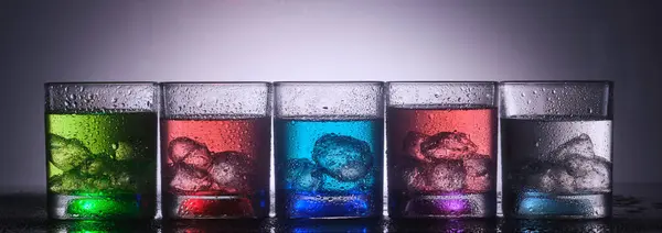 カラフルな液体と氷で満たされた鮮やかな眼鏡 ロイヤリティフリーのストック画像