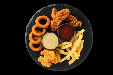 Nefis bir kızarmış tavuk, çıtır soğan halkaları ve nefis siyah tabakta lezzetli soslarla servis edilen altın patates kızartması karışımı..
