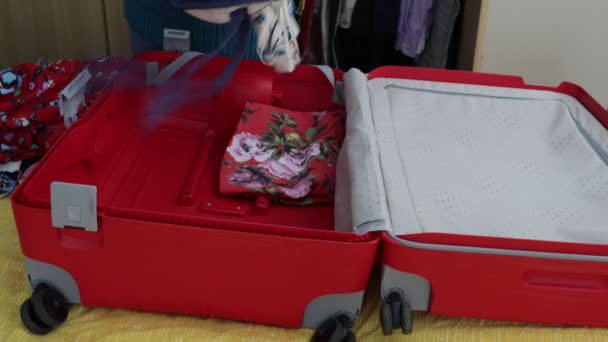 Female Hands Placing Organizing Clothes Red Suitcase Dresses Different Colors — Stock Video