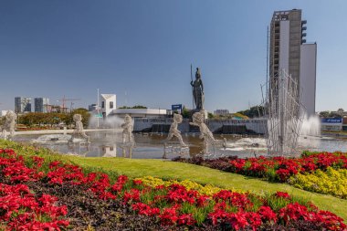 Guadalajara, Jalisco Meksika. 8 Ocak 2023. Glorieta Minerva kırmızı noktalı çiçeklerle ve Noel süslemesiyle, Roma tanrıçası heykeli fıskiyenin üstünde ve binalar da arka planda, güneşli bir günde