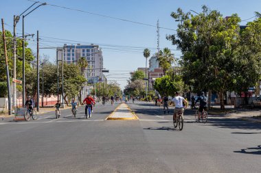 Guadalajara, Jalisco Meksika. 8 Ocak 2023. Hafta sonu eğlence rotası bisikletli insanlarla bulvar boyunca, mavi gökyüzüne karşı binalar arka planda, şehir manzarası, sokak spor için kapalı.