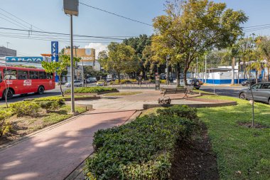 Guadalajara, Jalisco Meksika. 11 Ocak 2023. Bankalarla merkez rezervasyonu olan cadde, araba ve otobüs trafiği, Pablo Neruda doğrusal parkında güneşli bir gün, kentsel yaşam manzarası