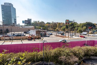 Guadalajara, Jalisco Meksika. 28 Aralık 2022. Şehirdeki sokaklar, dükkanlar, arabalar, reklam panoları, binalar ve bulanık arka planda yeşil ağaçlar, güneşli bir gün.