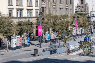 Guadalajara, Jalisco Meksika. 4 Şubat 2023. Arka plandaki sömürge binalarının önünde küçük ayakkabı boyama tezgahları olan yaya caddesinin havadan görünüşü, güneşli bir günün tadını çıkaran insanlar.