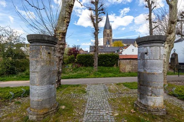 荷兰米登林堡的索恩市 有两根巨大而厚实的柱子 有一条人行横道 是圣迈克尔修道院教堂的房屋和钟楼 白云映衬蓝天 光秃秃的树木映衬着蓝天 — 图库照片
