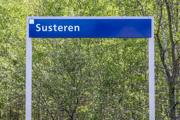 Jelzőtábla Holland Susteren Falu Nevével Zöld Lombozatú Leveles Fák Háttérben — Stock Fotó