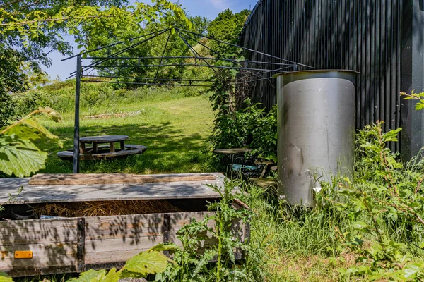 农场后院里堆积如山的野草 野营桌 储水的金属罐 帐篷的金属结构和有稻草的木箱 阳光灿烂的日子 — 图库照片