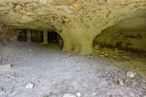 Cave with tunnels and concrete supports or columns in background, walls with uniform texture and cracks, Thier de Lanaye nature reserve in Belgian part of Sint-Pietersberg in Vise, Belgium