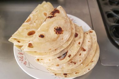 Lezzetli hazırlanmış quesadilla 'lar fırına konmaya hazır, beyaz seramik tabak, un tortilla, evde hazırlanmış geleneksel Tex-Mex yemekleri.