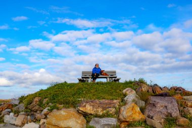 Turist bakış açısıyla tepede yaşlı bayan yürüyüşçüsüyle birlikte bir mola vermiş Belçika doğa rezervi De Wissen, Dilsen-Stokkem, Belçika 'da mavi gökyüzü ile güneşli bir gün.