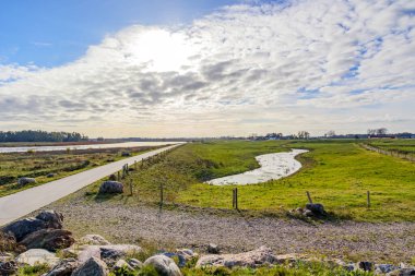 Belçika doğasındaki panoramik manzara De Wissen Maasvallei, yürüyüş yolu, kırsal alandaki su birikintileri, arka planda Maas nehri ve ufku, Dilsen-Stokkem, Belçika 'da bulutlu bir sonbahar günü